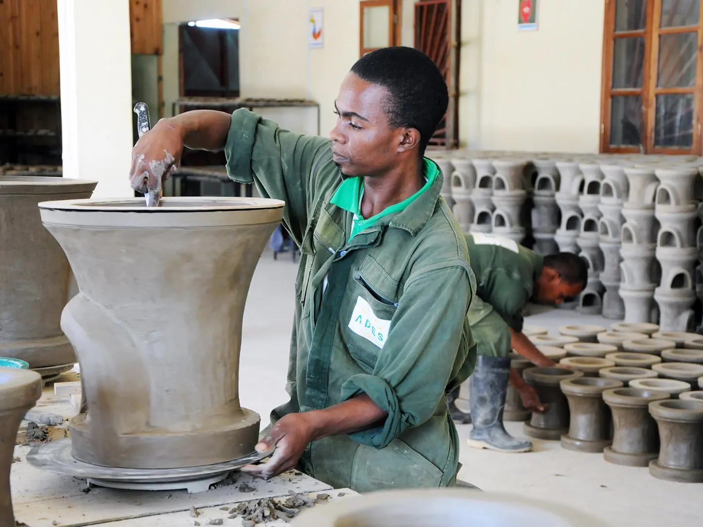 Benyamin Rakotovaomanana am Fertigstellen einer Ton Brennkammer eines Energiesparkochers für Schulen
