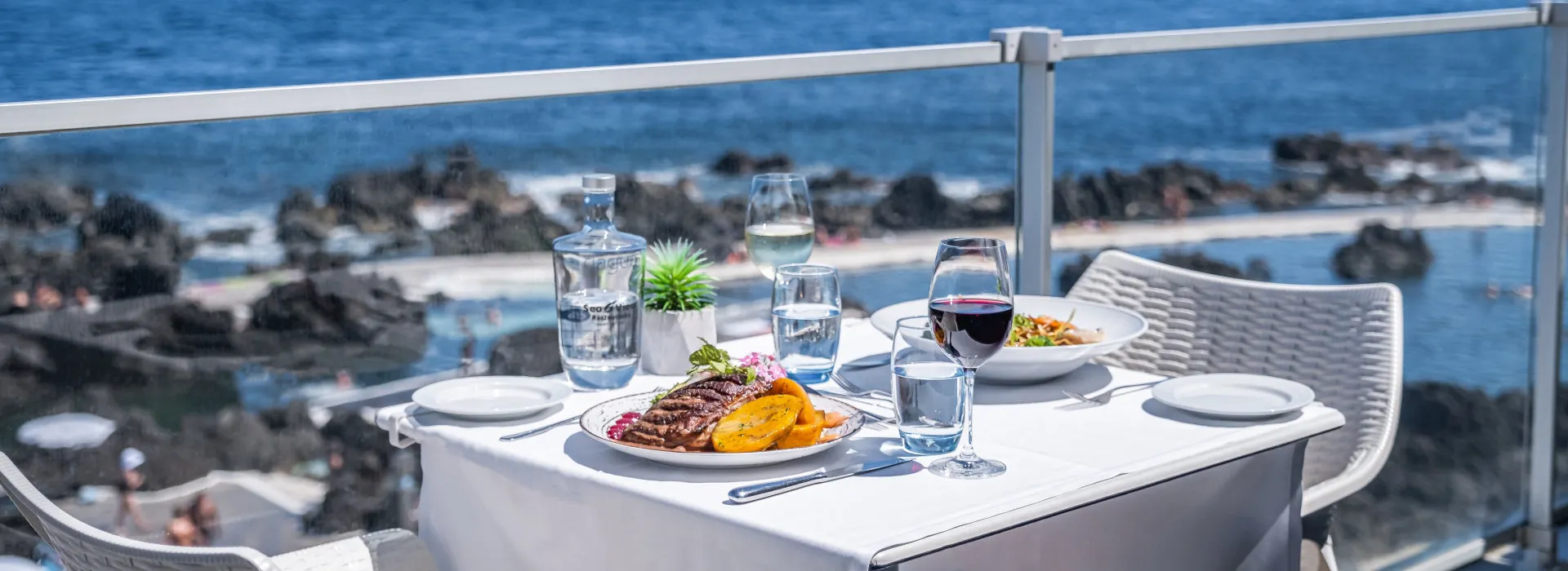 Gedeckter Tisch mit Meer im Hintergrund